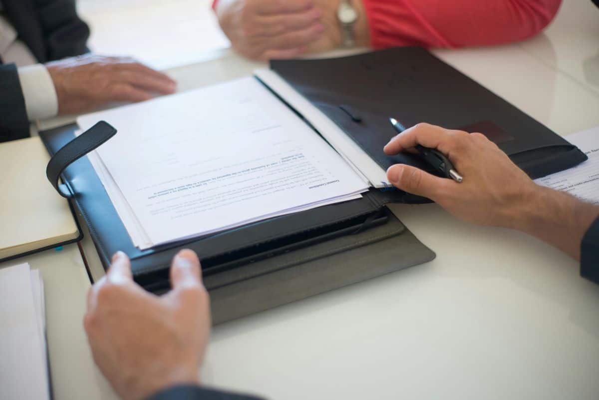 Family signing documents at closing table